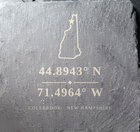 Natural slate coaster laser engraved with a New Hampshire outline, a star marking Colebrook, and GPS coordinates 44.8943° N, 71.4964° W